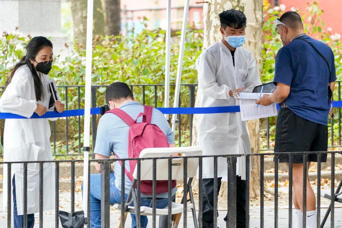 Health care workers with the New York City Department of Health and Mental Hygiene help people register for the monkeypox vaccine at one of the city's vaccination sites on July 26, 2022. (Mary Altaffer/AP Photo)