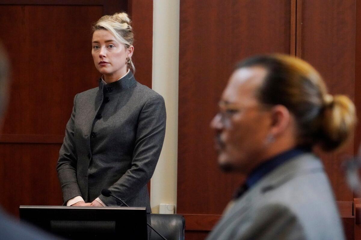 Actors Amber Heard and Johnny Depp watch as the jury leaves the courtroom for a lunch break at the Fairfax County Circuit Courthouse in Fairfax, Va., on May 16, 2022. (Steve Helber/Pool via AP)
