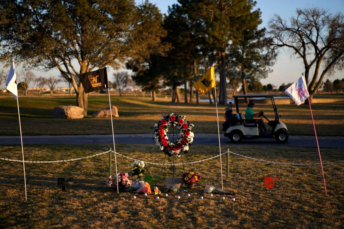 A golfer drives by a makeshift memorial at the Rockwind Community Links in Hobbs, N.M., on March 16, 2022. The memorial was for student golfers and the coach of University of the Southwest killed in a crash in Texas. (John Locher/AP Photo)