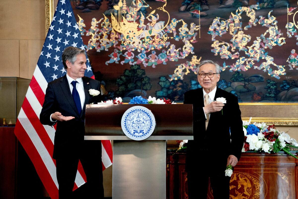 Thailand's Foreign Minister Don Pramudwinai (R) and U.S. Secretary of State Antony Blinken display flowers on their jackets following remarks to the press after a Memorandum of Understanding signing ceremony at the Thai Ministry of Foreign Affairs in Bangkok, Thailand, on July 10, 2022. (Stefani Reynolds/Reuters)