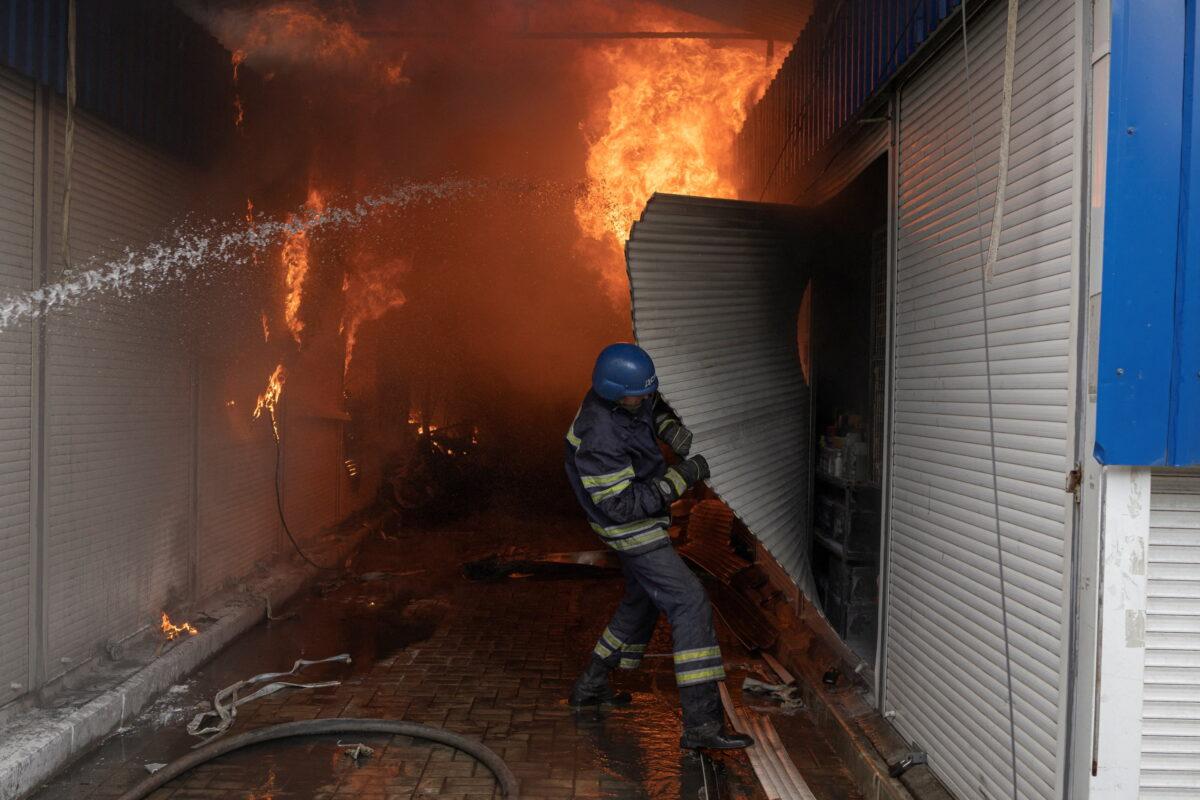 Firefighters spray water onto a fire at a market after shelling in Sloviansk, Donetsk region, Ukraine, on July 5, 2022, as Russia's attack on Ukraine continues. (Marko Djurica/Reuters)