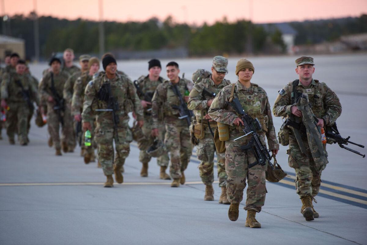 Soldiers with the 82nd Airborne division walk across the tarmac at Green Ramp to deploy to Poland at Fort Bragg, Fayetteville, North Carolina, on Feb. 14, 2022. (Melissa Sue Gerrits/Getty Images)