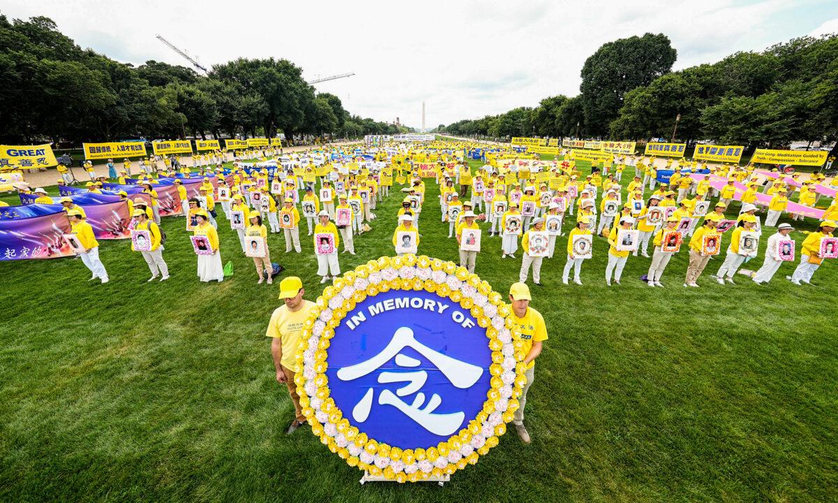 Falun Gong practitioners take part in a rally to commemorate the 23rd anniversary of the launch of the Chinese regime's persecution of the spiritual group Falun Gong, on the National Mall in Washington on July 21, 2022. (Larry Dye/The Epoch Times)