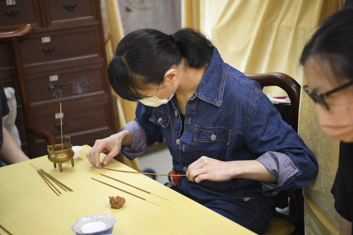 Aaron's student is making the incense on July 14, 2022. (Hui Tat/The Epoch Times)