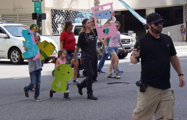 About 100 protesters marched with signs representing a range of issues, from abortion access to concerns about  LGBT issues, outside the Student Action Summit in Tampa, Fla., on July 23, 2022. (Natasha Holt/The Epoch Times)