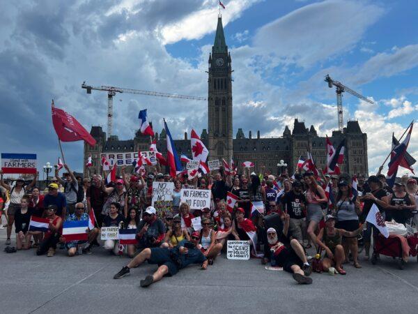 Supporters of a convoy protest pose for a photo as they gather on Parliament Hill in Ottawa in solidarity with Dutch farmers who are protesting the government's climate change policies, on July 23, 2022. (Annie Wu/The Epoch Times)