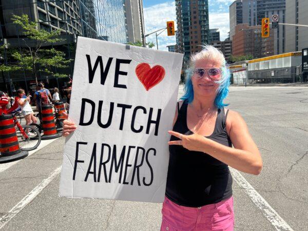 A woman holds a sign in support of farmers protesting the Dutch government's climate change policies, in Ottawa, Canada, on July 23, 2022. (Annie Wu/The Epoch Times)