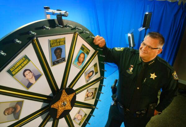  Brevard County Sheriff Wayne Ivey gets ready to spin his popular "Wheel of Fugitive" in Titusville, Fla. (Malcolm Denemark/Florida Today via AP)
