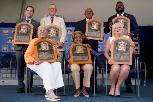 Clockwise from top left, Josh Rawitch, president of the National Baseball Hall of Fame and Museum, holding the plaque of inductee Bud Fowler, inductee Jim Kaat, inductee Tony Oliva, inductee David Ortiz, Sharon Rice-Minoso, holding the plaque of her husband and inductee Minnie Minoso, Dr. Angela Terry, holding the plaque of her uncle and inductee John Jordan O'Neil, and Irene Hodges, holding the plaque of her father and inductee Gil Hodges, pose for a photo at the conclusion of the National Baseball Hall of Fame induction ceremony, at the Clark Sports Center in Cooperstown, N.Y., on July 24, 2022. (John Minchillo/AP Photo)