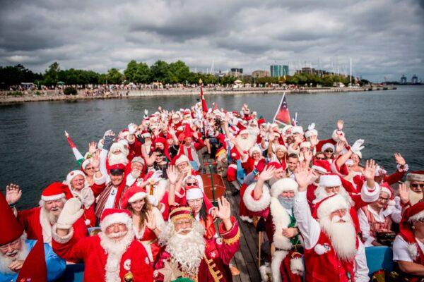 People dressed as Santa Claus wave as they take part in a canal tour that is part of the annual World Santa Claus congress in Copenhagen, Denmark, on July 23, 2018. (Mads Claus Rasmussen/AFP via Getty Images)