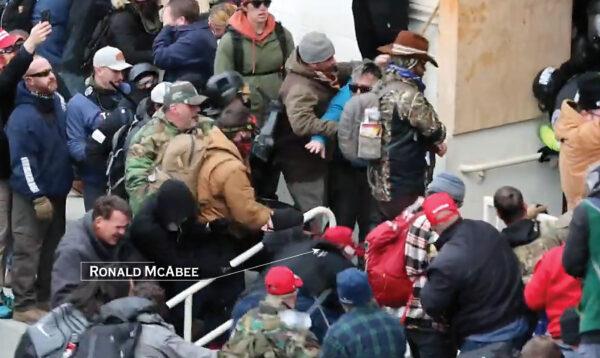 Ronald McAbee falls on top of Metropolitan Police Department Officer Andrew Wyatt after being pulled from behind on Jan. 6, 2021. (Christopher Chern via Storyful/Graphic by The Epoch Times)