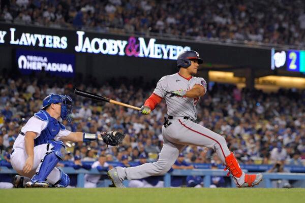 Washington Nationals' Juan Soto, right, hits a two RBI triple as Los Angeles Dodgers catcher Will Smith watches during the fifth inning of a baseball game, in Los Angeles, on Monday, July 25, 2022. (Mark J. Terrill/AP Photo)