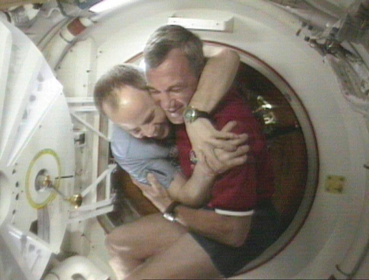 Shuttle Commander Terrence Wilcutt (R) and Mir Commander Anatoly Solovyev (L) hug after opening the hatches between the space shuttle Endeavour and the Russian Space station Mir on Jan. 24, 1998, in this image from television. (NASA via AP)