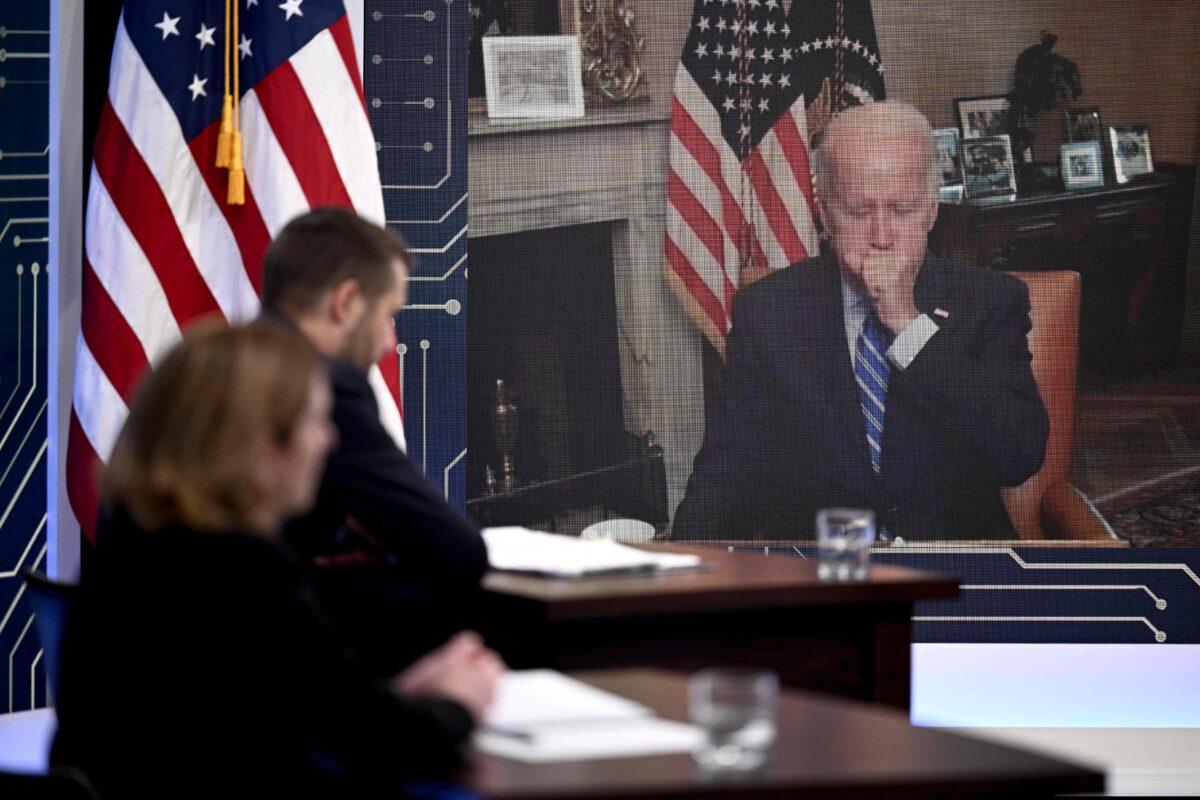 President Joe Biden covers his mouth while coughing during a virtual meeting with CEOs and labor leaders regarding the Chips Act, in Washington on July 25, 2022. (Brendan Smialowski/AFP via Getty Images)