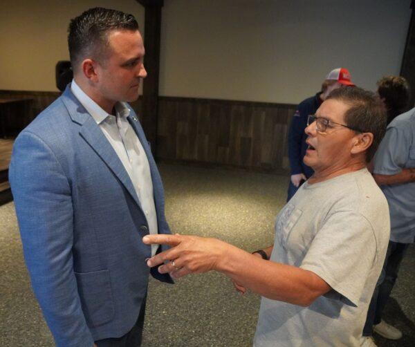  Garrett Soldano, candidate for governor of Michigan, discusses the issues with a voter in Croswell, Mich. on May 21, 2022. (Steven Kovac/Epoch Times)