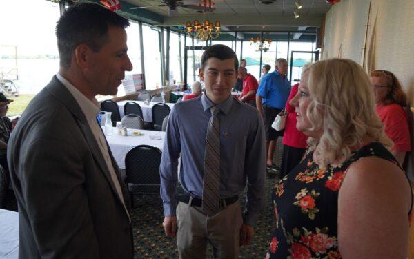  GOP gubernatorial candidate Ryan Kelley (L) talks with a 19-year-old precinct delegate and an angry mom who's running for school board in St. Clair, Mich. on July 26, 2022. (Steven Kovac/Epoch Times)