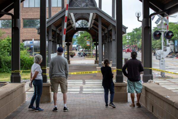 People look past crime tape near the scene of a mass shooting at a Fourth of July parade in Highland Park, Ill., on July 6, 2022. (Jim Vondruska/Getty Images)