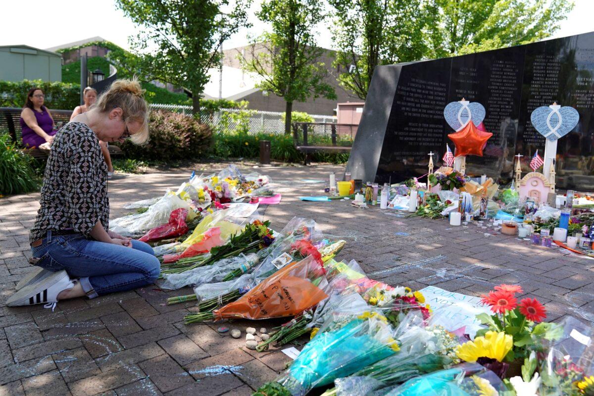 A visitor prays at a memorial to the seven people killed and others injured in the Fourth of July shooting at the Highland Park War Memorial in Highland Park, Ill., on July 7, 2022. (Nam Y. Huh/AP Photo)