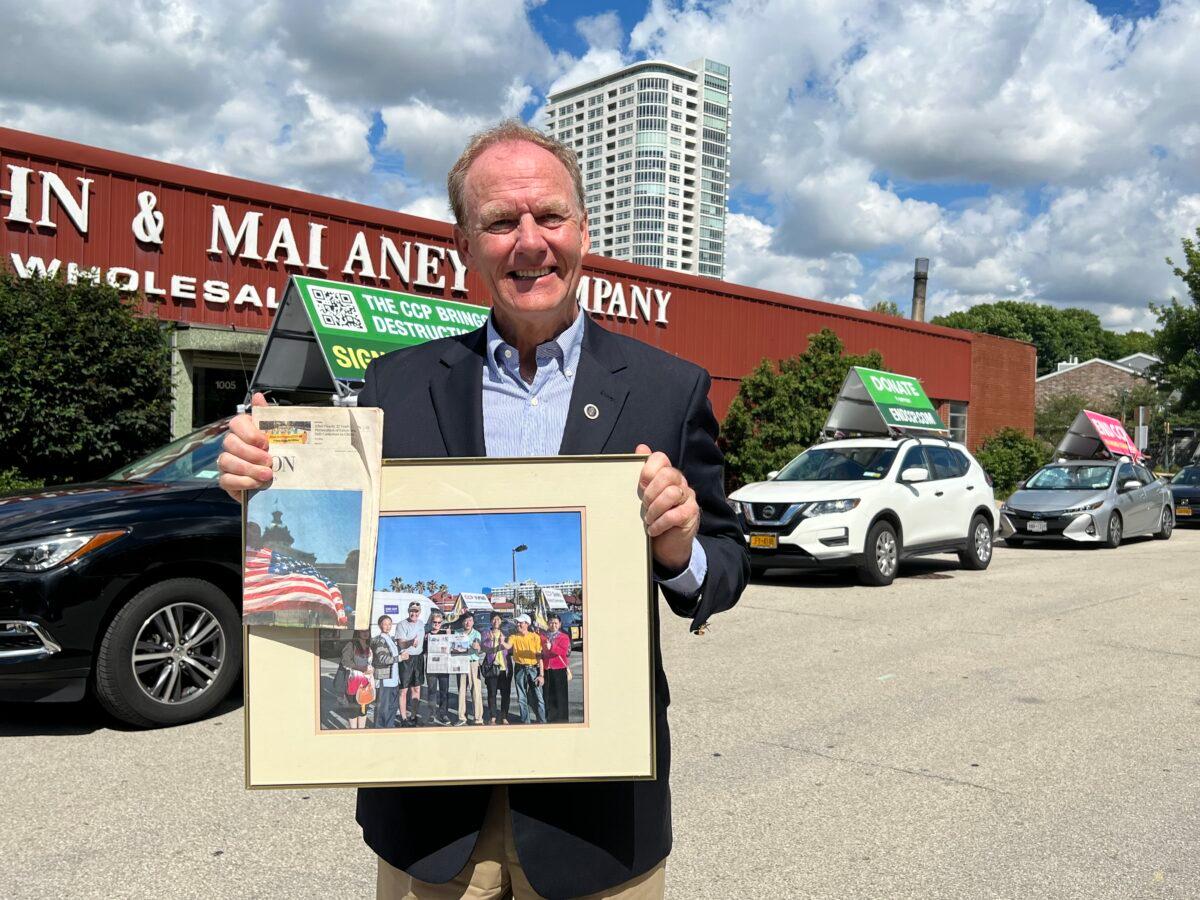 Milwaukee resident and financial service business owner Jefferson Davis holds a framed photo of a previous EndCCP Tour as he welcomes the fourth EndCCP Tour convoy in Milwaukee, Wis., on July 26, 2022. (Sarah Lu/Epoch Times)