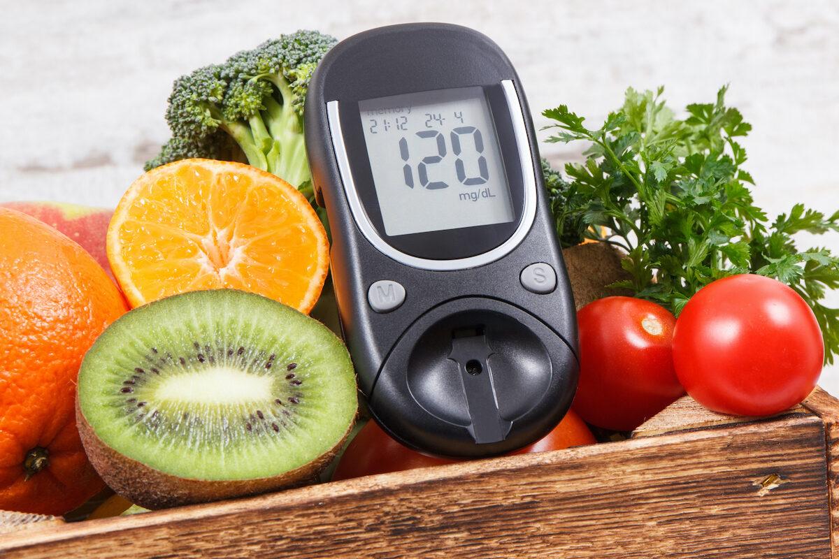Glucose meter and fresh ripe natural fruits with vegetables. Concept of checking sugar level, diabetes, healthy lifestyles and nutrition. (Shutterstock）