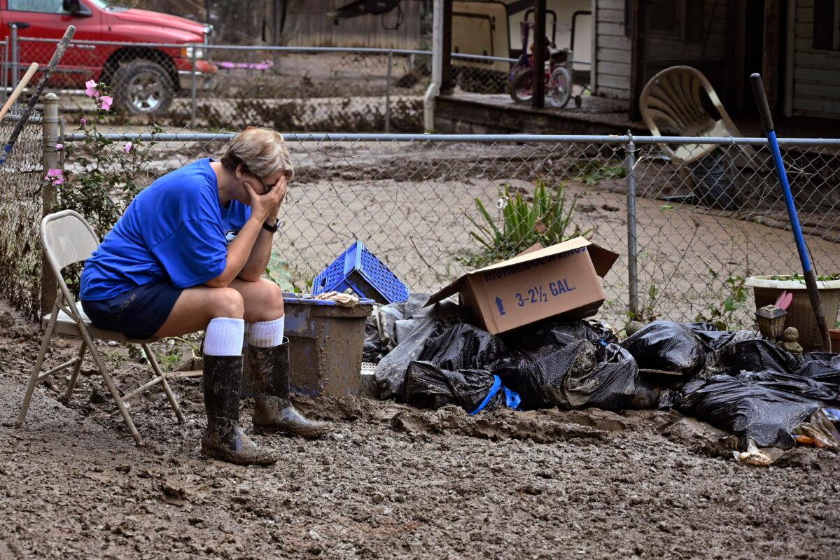 Teresa Reynolds sits exhausted as members of her community clean the debris from their flood ravaged homes at Ogden Hollar in Hindman, Ky., on July 30, 2022. (Timothy D. Easley/AP Photo)
