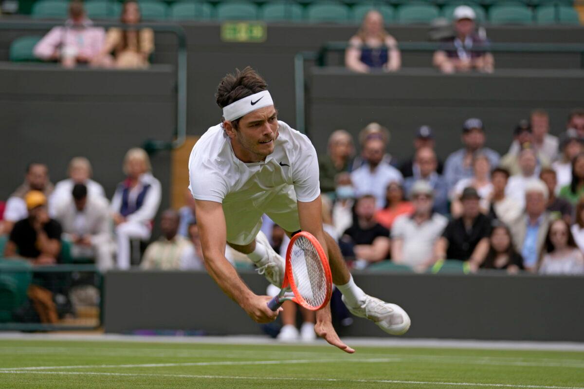 Taylor Fritz of the United States dives to make a return to Australia's Jason Kubler in a men's singles fourth round match on day eight of the Wimbledon tennis championships in London on July 4, 2022. (Alastair Grant/AP Photo)