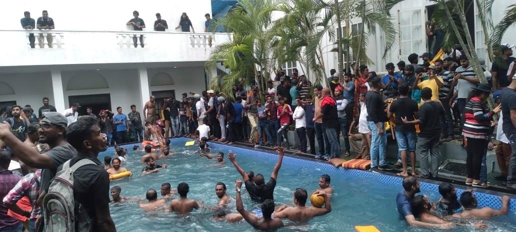 Protesters swim in a swimming pool of the Sri Lankan president's official residence after storming into it in Colombo, Sri Lanka, on July 9, 2022. (AP Photo)