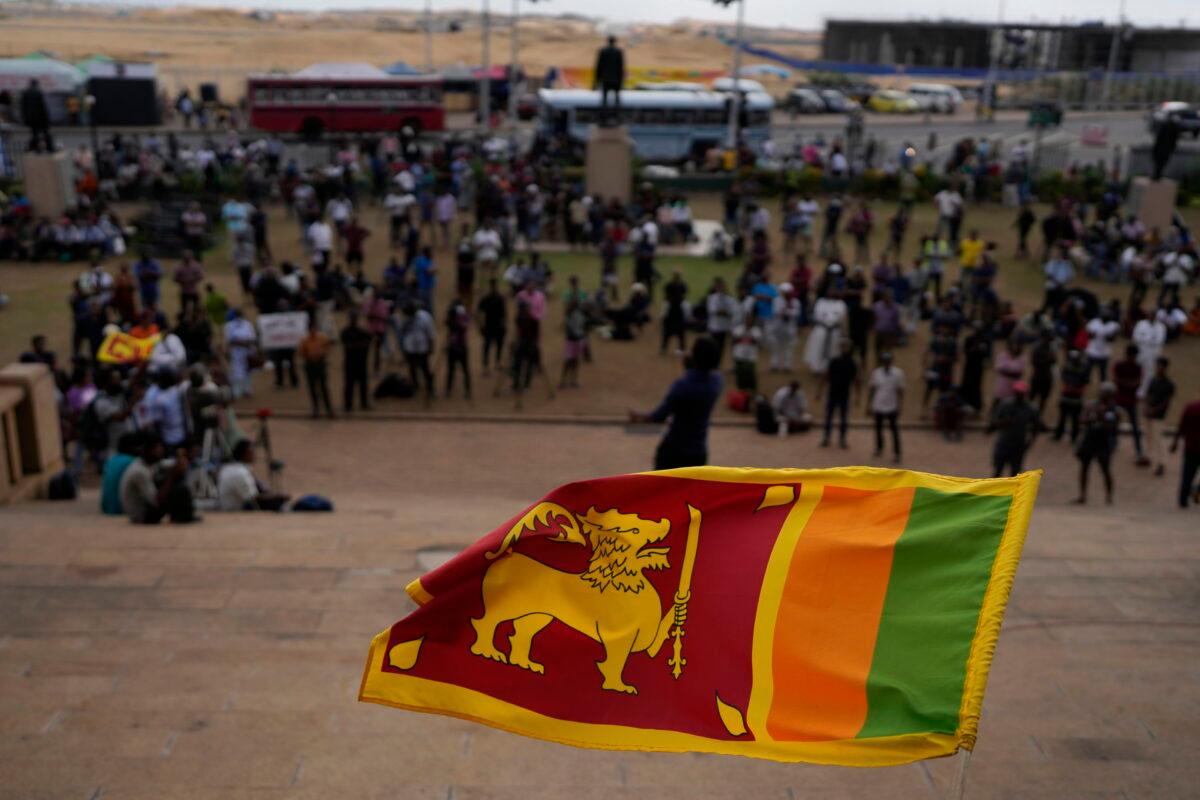 A Sri Lankan flag is waved by a protester demanding elected president Ranil Wickremesinghe step down in Colombo, Sri Lanka, on July 20, 2022. Sri Lanka's prime minister was elected president Wednesday by lawmakers who opted for a seasoned, veteran leader to lead the country out of economic collapse, despite widespread public opposition. (AP Photo/Rafiq Maqbool)