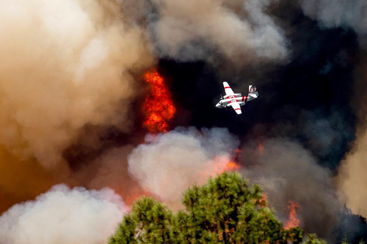 An air tanker flies past flames while battling the Oak Fire in Mariposa County, Calif., on July 24, 2022. (Noah Berger/AP Photo)