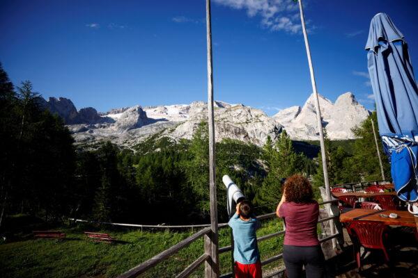 People look at the site of a deadly collapse of parts of a mountain glacier in the Italian Alps amid record temperatures, at Marmolada ridge, Italy, on July 5, 2022. (Guglielmo Mangiapane/Reuters)