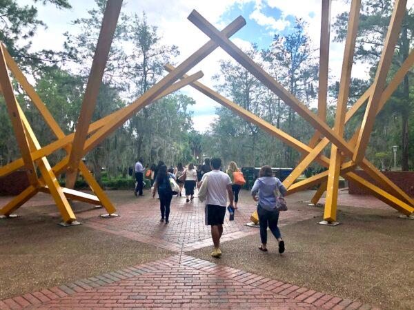 New students attending orientation at the University of Florida stroll past a metal sculpture on campus unofficially known as "The French Fries" on June 6, 2022. (Natasha Holt/The Epoch Times)