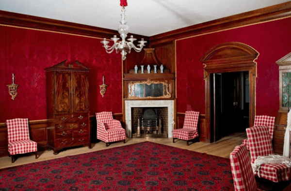 The Middle Room was where important business was conducted. Deep burgundy leather hangings on the wall and burgundy and blue rug, create a formal mood. (The Colonial Williamsburg Foundation)