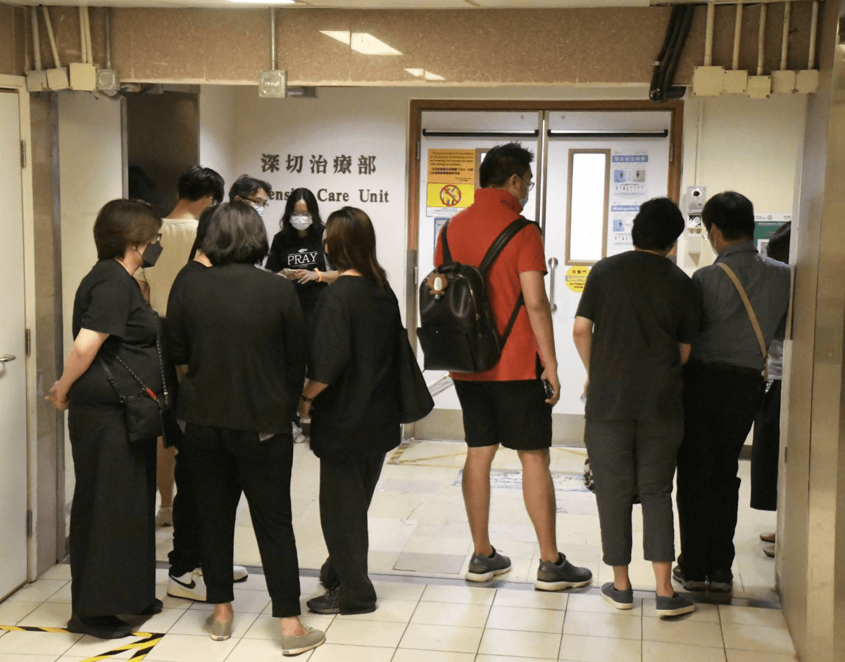 Family and staff members await at the Intensive Care Unit of Queen Elizabeth Hospital after a serious accident at Mirror’s concert at the Hong Kong Coliseum on July 29, 2022. (Big Mack/The Epoch Times)