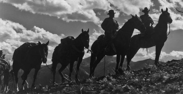 Two cowboys on horseback, leading pack horses on a mountainside in Montana, circa 1950. (John C. Haberstroh/FPG/Archive Photos/Getty Images)