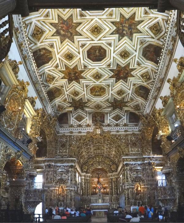 Another of the church’s striking elements is the wooden ceiling, created by artist José Joaquim da Rocha in 1774. The ceiling was painted in an illusionistic perspective, a Renaissance technique used to create the illusion of depth. The wooden carvings in star, diamond, and octagonal shapes hold sacred paintings. Both the ceiling and pulpit are decorated with biblical scenes, and the azulejos display allegorical scenes with moral messages from Roman mythology. (<a href="https://commons.wikimedia.org/wiki/Category:Larissa">Larissa Thans Carneiro</a>/ <a href="https://creativecommons.org/licenses/by-sa/4.0/deed.en">CC BY-SA 4.0</a>)
