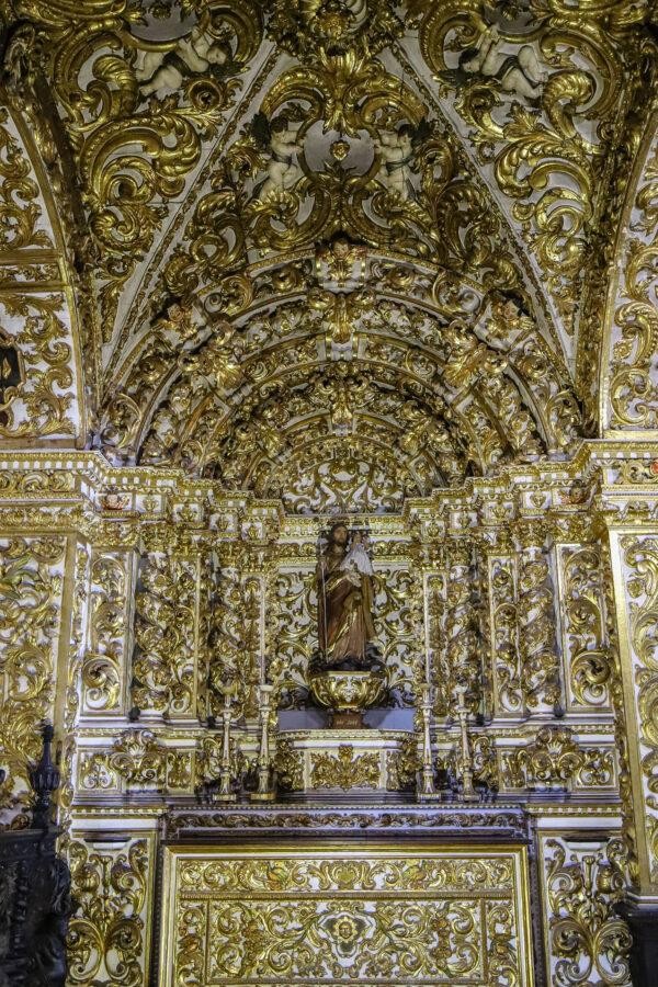 This side chapel, dedicated to the veneration of St. Joseph and used for private prayer, displays impressive gilded woodwork and elaborate arches. Angels, flowers, leaves, and birds intertwine throughout the backdrop and around the altar. This shows the unique Brazilian Baroque art and architecture based on the 18th-century European Baroque style. (<a href="https://en.wikisource.org/wiki/Author:Paul_Robert_Burley">Paul R. Burley</a>/ <a href="https://creativecommons.org/licenses/by-sa/4.0/deed.en">CC BY-SA 4.0</a>)