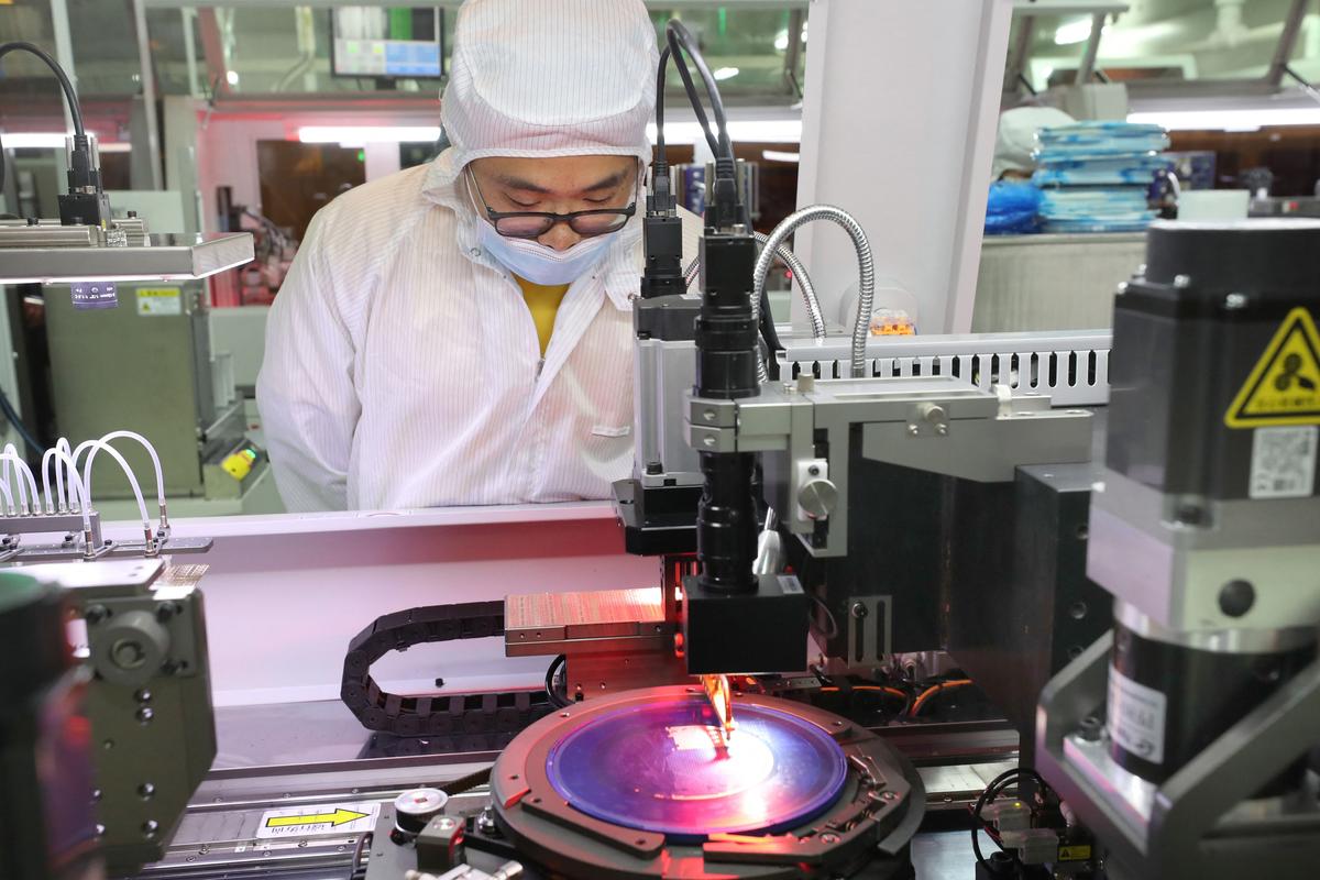 An employee makes a chip at a factory of Jiejie Semiconductor Company in Nantong, in eastern China's Jiangsu province, on March 17, 2021. (STR/AFP via Getty Images)
