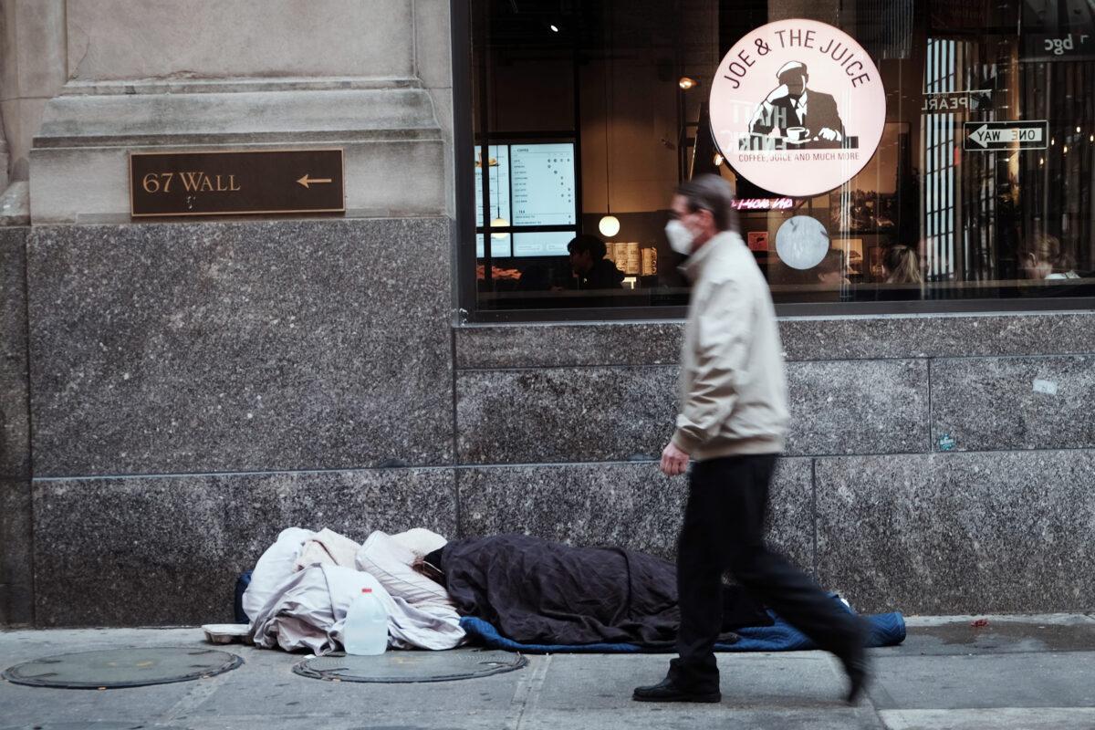 A homeless person sleeps along Wall Street on April 28, 2022 in New York City. (Spencer Platt/Getty Images)