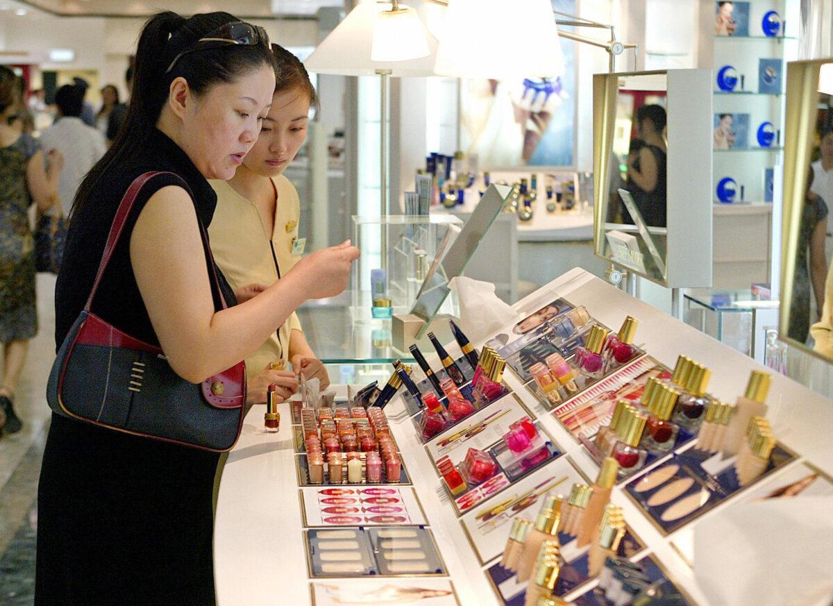 A woman checks out the lipsticks at a department store in Shanghai, Aug. 16, 2004. (LiuJin/AFP via Getty Images)
