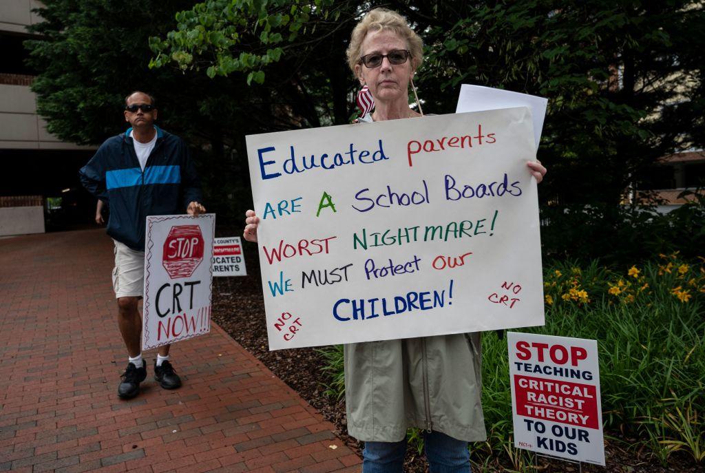 People hold up signs during a rally against critical race theory being taught in schools at the Loudoun County Government center in Leesburg, Va., on June 12, 2021. (Andrew Caballero-Reynolds/AFP via Getty Images)