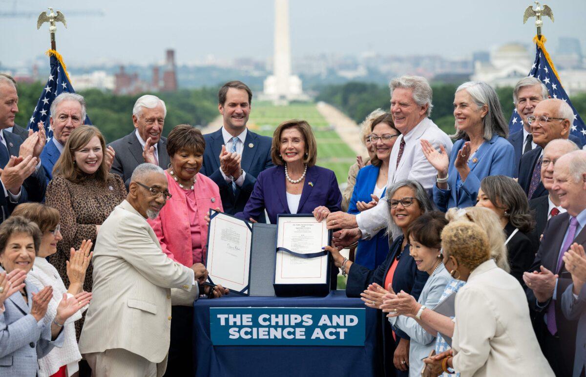 House Speaker Nancy Pelosi, alongside House Democrats, holds the CHIPS for America Act, providing domestic semiconductor manufacturers with billions in subsidies to cut reliance on foreign sourcing, after signing it during an enrollment ceremony outside the U.S. Capitol in Washington on July 29, 2022. (Saul Loeb/AFP via Getty Images)
