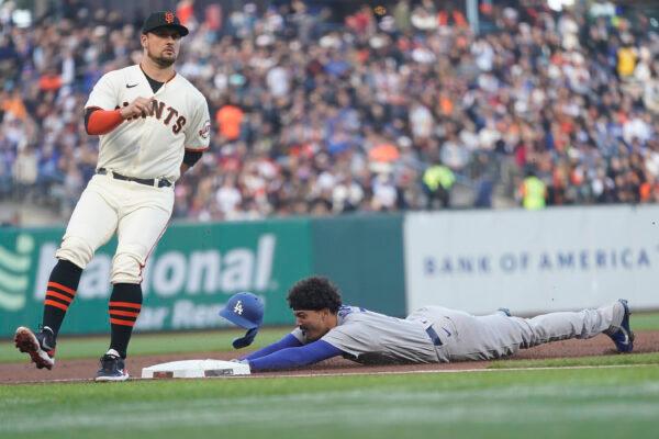 Los Angeles Dodgers' Miguel Vargas, right, steals third base next to San Francisco Giants third baseman J.D. Davis during the second inning of a baseball game in San Francisco, Wednesday, Aug. 3, 2022. (AP Photo/Jeff Chiu)