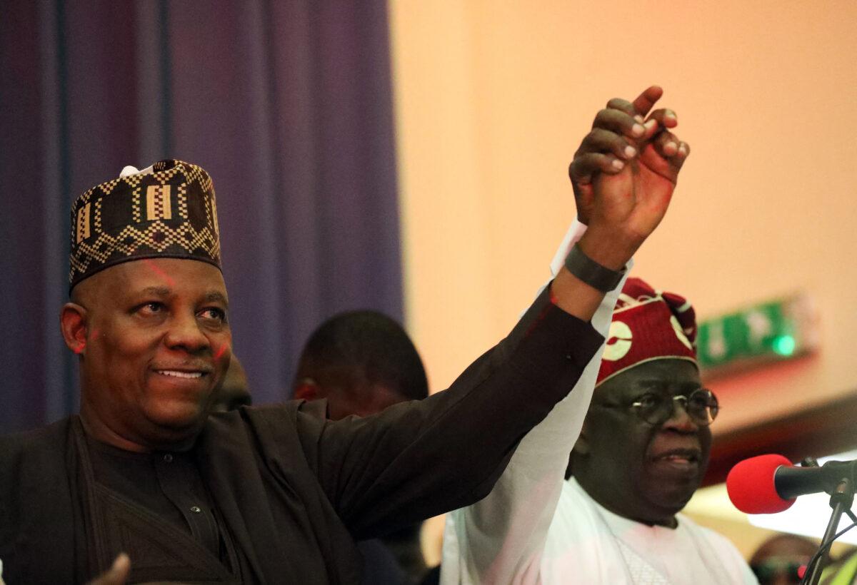  Nigeria's All Progressives Congress (APC) ruling party presidential candidate Bola Ahmed Tinubu (R) holds the arm of Kashim Shettima (L) during an APC meeting to unveil Shettima as its vice-presidential flagbearer in Abuja on July 20, 2022. (Kola Sulaimon/AFP via Getty Images)