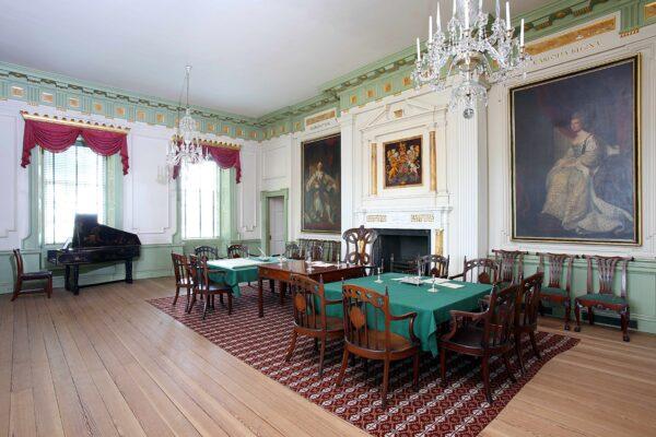 The Council Chamber, where the governor’s council, the upper house of the legislature, would meet. The doorframes and wainscot are a lush, green color. The walls are further adorned with a painting of King George III, and his coat of arms. (Courtesy of Tryon Palace)