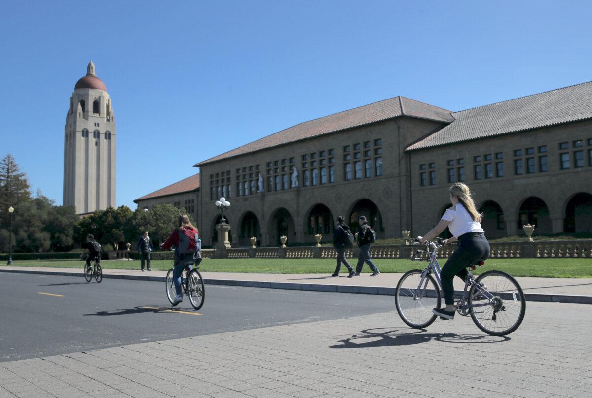 Cyclists ride by Hoover Tower on the Stanford University campus in Stanford, Calif., on March 12, 2019. (Justin Sullivan/Getty Images)