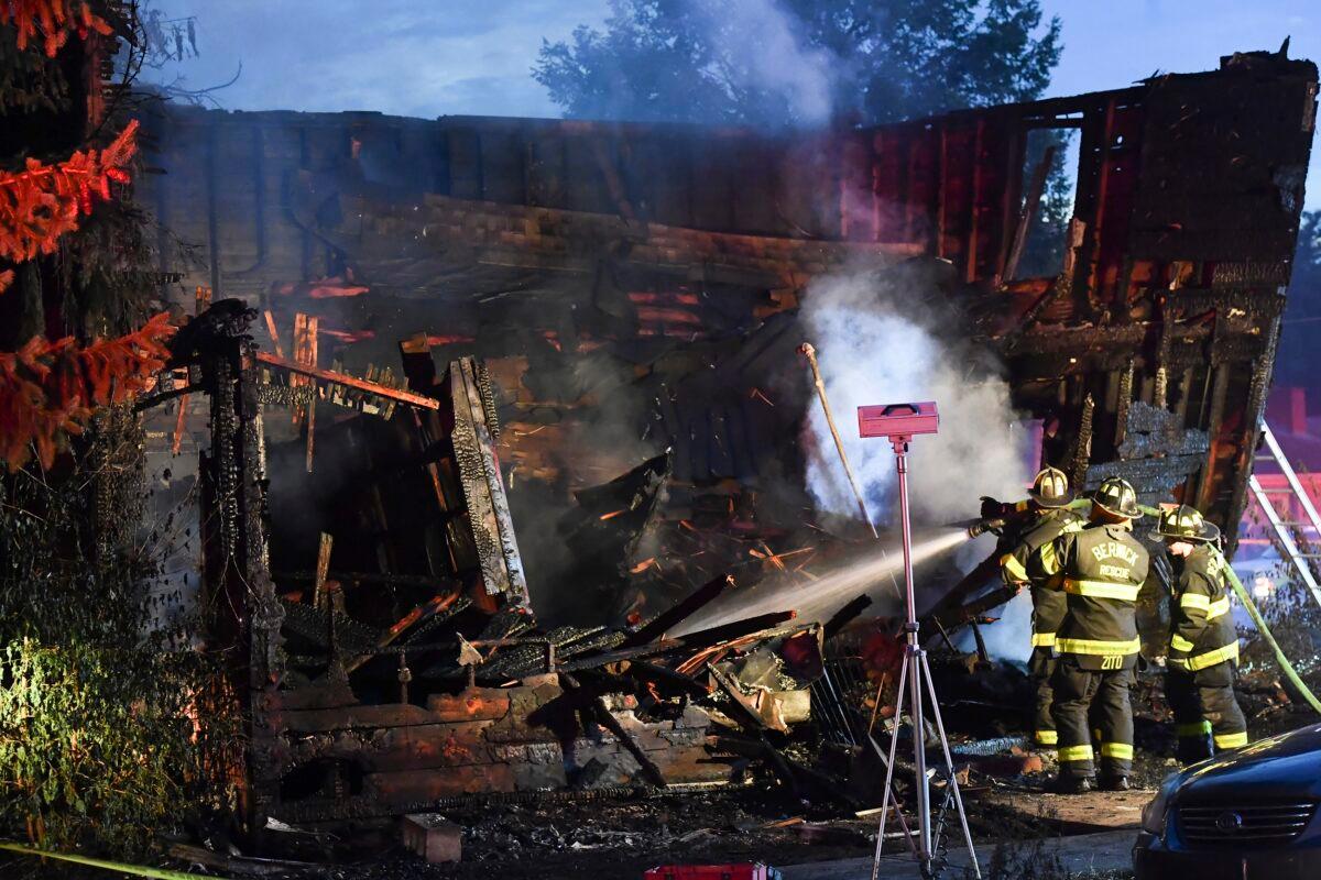Firefighters work on hot spots in the front section of the home which collapsed during an early morning fatal fire on First Street in Nescopeck, Pa., on Aug. 5, 2022. (Jimmy May/Bloomsburg Press Enterprise via AP)
