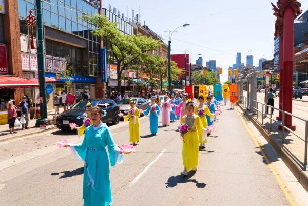 Falun Gong adherents take part in a parade through Toronto's Chinatown to celebrate 400 million Chinese people quitting the Chinese Communist Party and its affiliated organizations, on Aug. 6, 2022. (Evan Ning/The Epoch Times)