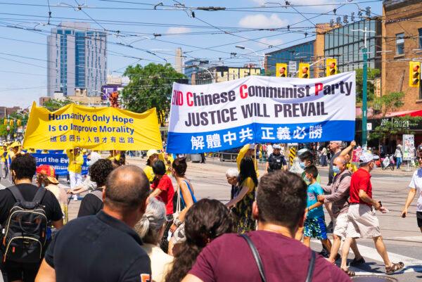People watch a parade in downtown Toronto to celebrate 400 million Chinese people quitting the Chinese Communist Party and its affiliated organizations, on Aug. 6, 2022. (Evan Ning/The Epoch Times)