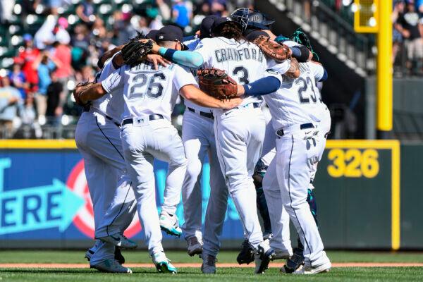 Seattle Mariners players celebrate with a group dance in center field after defeating the Los Angeles Angels in the first game of a baseball doubleheader in Seattle, Saturday, Aug. 6, 2022. (Caean Couto/AP Photo)