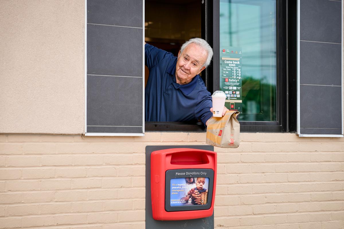 McDonald's owner Tony Philiou delivers food at the drive-through window on Aug. 8, 2022. (Roger Mastroianni for The Epoch Times)
